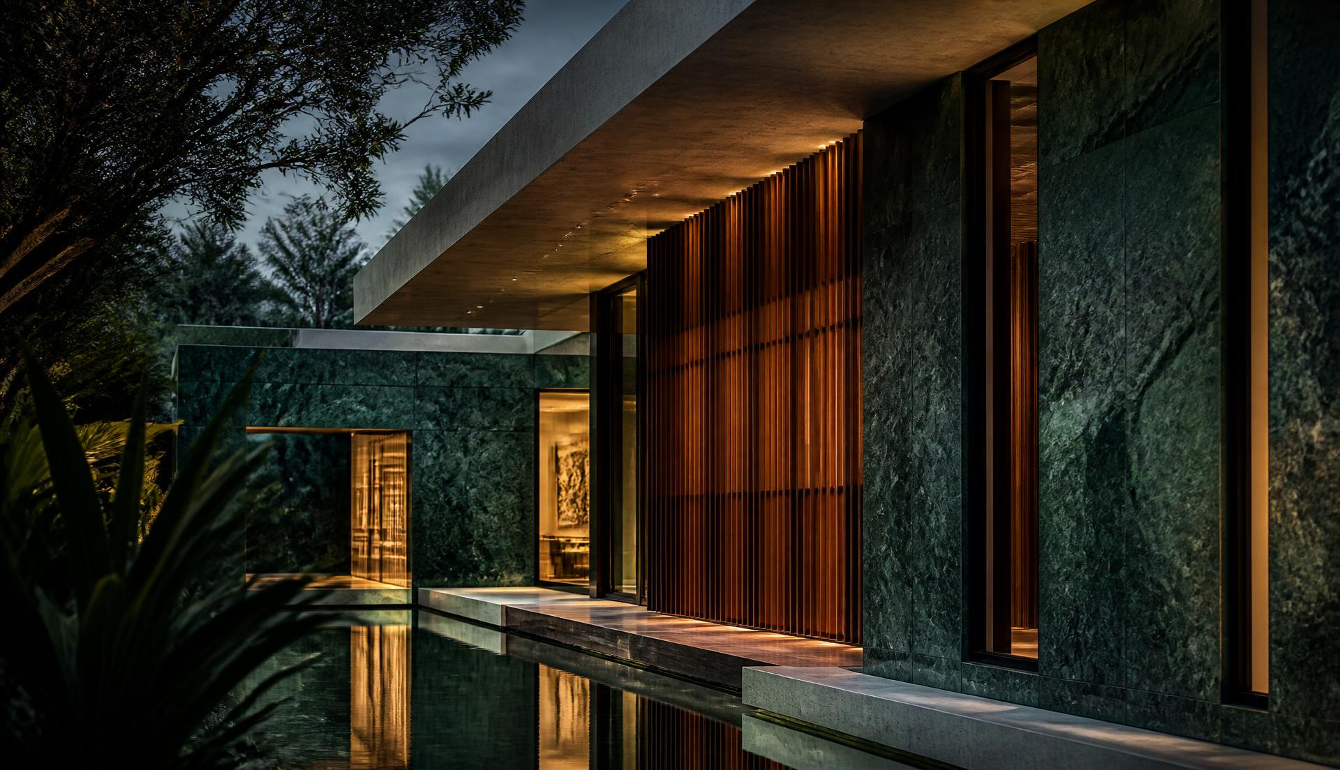 Emerald stone and teak villa facade at blue hour with warm interior light and a still reflecting water channel